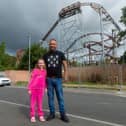 Jack Welsh and his daughter Sapphire Rose-Welsh, next to a rollercoaster built next to a housing estate in Hucknall, nr. Nottingham