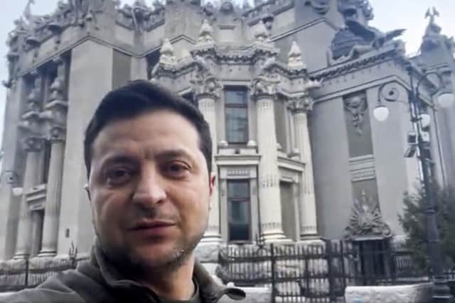 In this photo provided by the Ukrainian Presidential Press Office, Ukrainian President Volodymyr Zelenskyy speaks to the nation via his smartphone in the center of Kyiv, Ukraine, on Saturday,