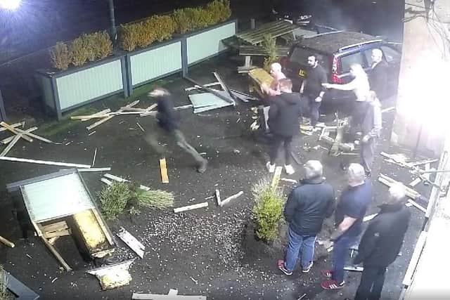 The dazed driver and his passenger emerge from the wreck and run away as stunned customers flood out of the pub