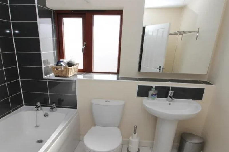 The property has two bathrooms and two separate en-suite showers and WCs. This one has a panel bath with a shower, a low level WC, a hand basin, with tiled splash back and flooring.