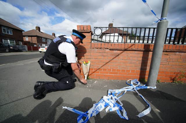 A police officer lays flowers near to the scene in Kingsheath Avenue, Knotty Ash, Liverpool, where a nine-year-old girl has been fatally shot. Officers from Merseyside Police have started a murder investigation after attending a house at 10pm Monday following reports that an unknown male had fired a gun inside the property. Picture date: Tuesday August 23, 2022.