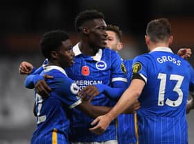 Tariq Lamptey of Brighton and Hove Albion celebrates with teammates Yves Bissouma and Pascal Gross. (Photo by Mike Hewitt/Getty Images)