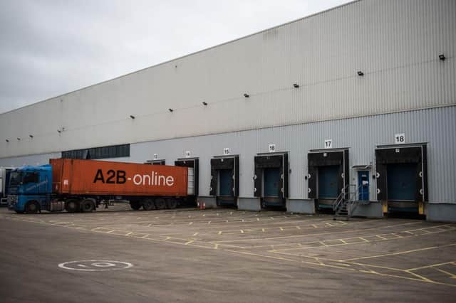 Lorries operate at the loading bays of a depot of The NX Group (OLI SCARFF/AFP via Getty Images)