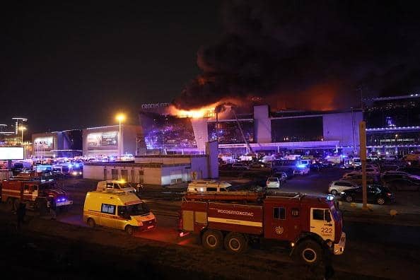 Emergency services vehicles are seen outside the burning Crocus City Hall concert hall following the shooting incident in Krasnogorsk, outside Moscow