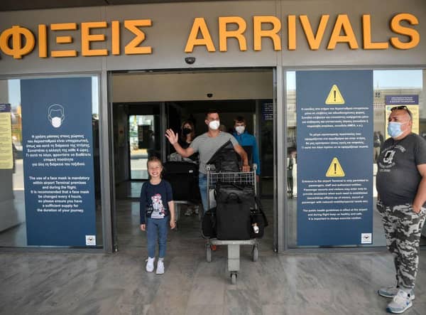 A tourist waves as he leaves the international airport of Heraklion (Photo: LOUISA GOULIAMAKI/AFP via Getty Images)