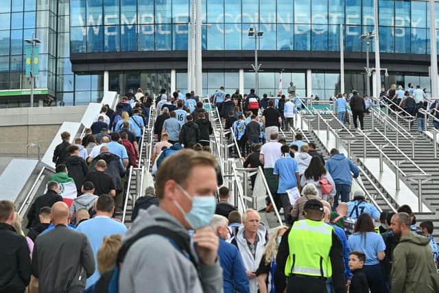 Spectators arrive at Wembley Stadium in north London on August 7, 2021 to watch the English FA Community Shield football match between Manchester City and Leicester City.