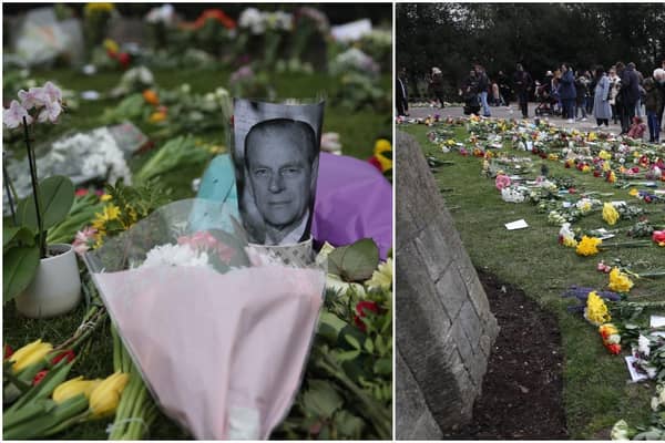 People look at flowers left outside Windsor Castle, Berkshire, following the announcement of the death of the Duke of Edinburgh at the age of 99 (Getty Images)