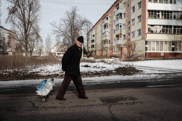 A man carries water containers along the street in Bakhmut on February 9, 2023, amid the Russian invasion of Ukraine. (Photo by YASUYOSHI CHIBA / AFP) (Photo by YASUYOSHI CHIBA/AFP via Getty Images)