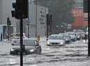 Cars drive through deep water on a flooded road in The Nine Elms district of London on July 25, 2021 during heavy rain (AFP/Getty)