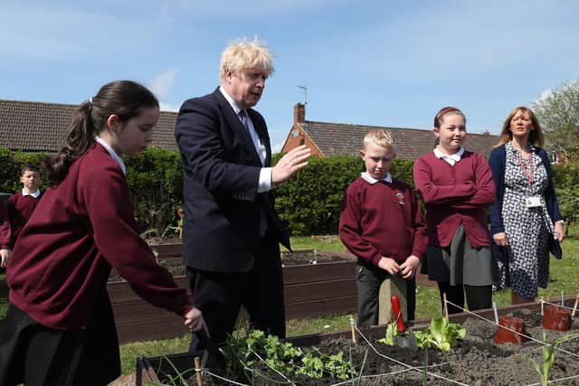 Prime Minister Boris Johnson helps out in the vegetable garden during a visit to Cleves Cross Primary school in Ferryhill, County Durham (PA).