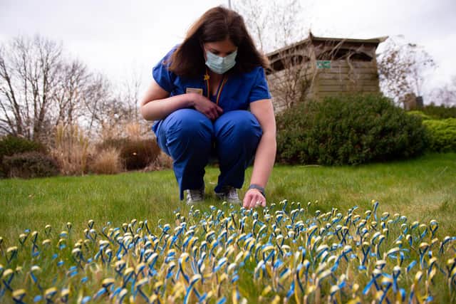 Consultant in Palliative Medicine Nikki Reed lays ribbons in the shape of a heart to commemorate the lives of patients at Marie Curie West Midlands Hospice in Solihull lost during the coronavirus pandemic