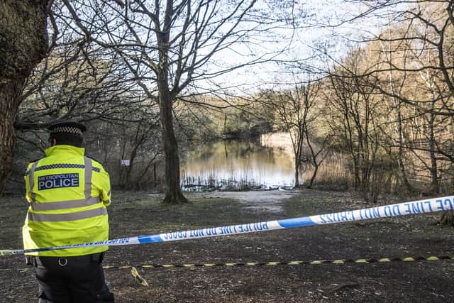 A Metropolitan Police officer stands at the scene at the Wake Valley pond in Epping Forest.