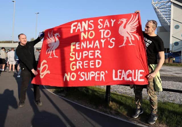 Fans hold up a protest banner against Liverpool FC and the European Super League outside Elland Road before the Reds took on Leeds United.
