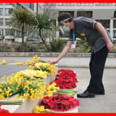 A member of staff places flowers near the statue of Crimean War nurse Mary Seacole during a ceremony to observe a minute's silence at St Thomas' Hospital, central London