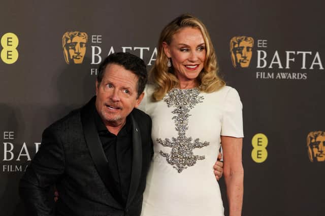 Canadian actor Michael J Fox, left, and his wife US actress Tracy Pollan pose on the red carpet upon arrival at the Baftas. (Picture: Adrian Dennis/AFP via Getty Images)