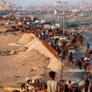 Displaced Palestinians evacuating southbound from Gaza City travel on foot and by vehicle along the coastal road in Nuseirat in the central Gaza Strip on September 13, 2025. (Photo by EYAD BABA/AFP via Getty Images)