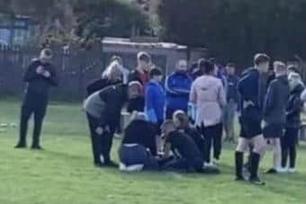 Referee Dave Bradshaw is helped by onlookers