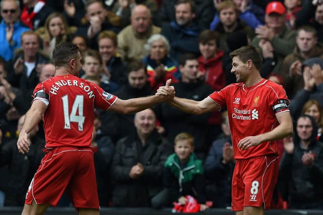 Liverpool's English midfielder Steven Gerrard (R) celebrates with Liverpool's English midfielder Jordan Henderson after scoring the winning goal during the English Premier League football match between Liverpool and Queens Park Rangers at the Anfield stadium in Liverpool, northwest England, on May 2, 2015.  AFP PHOTO / PAUL ELLIS