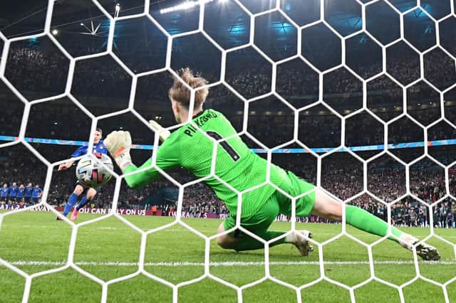 England's goalkeeper Jordan Pickford saves a shot by Italy's forward Andrea Belotti in the penalty shootout (Photo by PAUL ELLIS/AFP via Getty Images)