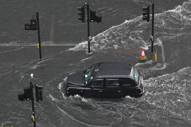 A London taxi drives through water on a flooded road in The Nine Elms district of London on July 25, 2021 during heavy rain (Justin Tallis/AFP/Getty)