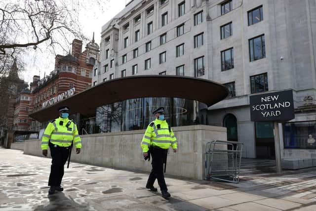 Police officers wearing face coverings due to Covid-19 walk past New Scotland Yard, the headquarters of the Metropolitan Police Service. Officer Benjamin Hannam was found guilty of being a member of banned group National Action.