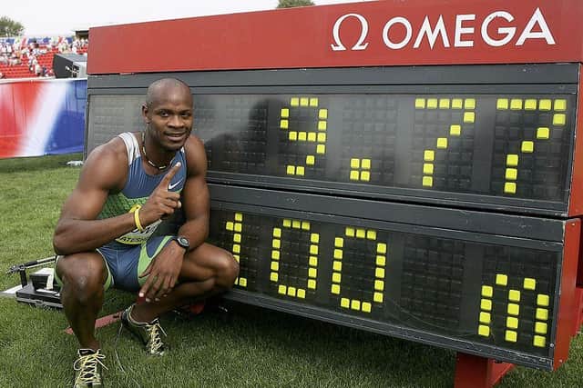 Asafa Powell of Jamaica poses with the scoreboard after equaling the world record in the men's 100 meters final during the Norwich Union British Grand Prix at Gateshead International Stadium June 11, 2006.