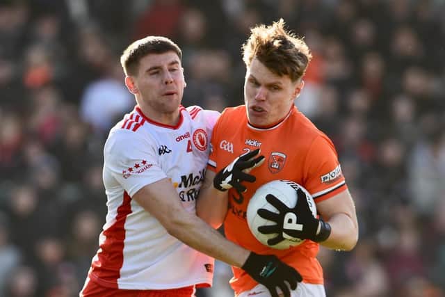 Armagh's Oisin O'Neill takes a trackle from Tyrone's Niall Devlin.