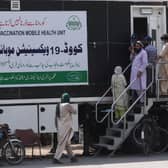 People wait for their turn to get a dose of a vaccine against the Covid-19 coronavirus outside a mobile vaccination health unit in Lahore, Pakistan (Photo: ARIF ALI/AFP via Getty Images)