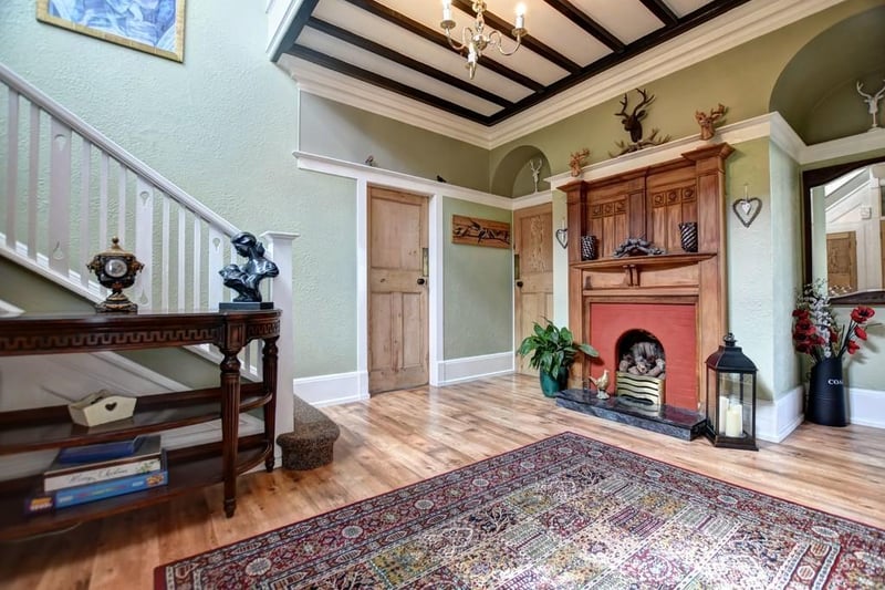 The entrance hall features a timber open fireplace with granite hearth.