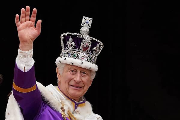 King Charles III wearing the Imperial state Crown, waves from the Buckingham Palace balcony after viewing the Royal Air Force fly-past in central London in May  last year after his coronation. Photo: STEFAN ROUSSEAU/POOL/AFP via Getty Images)