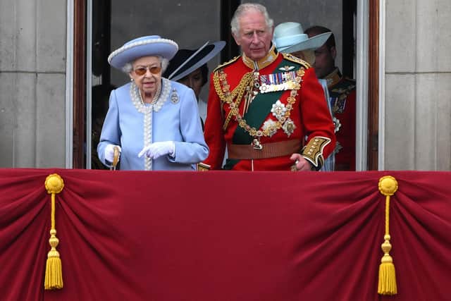 Queen Elizabeth and Prince Charles stand on the balcony of Buckingham Palace to watch a special flypast yesterday (Picture: Daniel Leal/AFP via Getty Images)