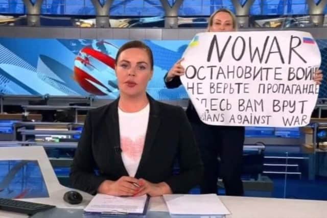 This video grab taken on March 15, 2022 shows Russian Channel One editor Marina Ovsyannikova holds a poster reading " Stop the war. Don't believe the propaganda. Here they are lying to you"  during on-air TV studio by news anchor Yekaterina Andreyeva , Russia's most-watched evening news broadcast, in Moscow on March 14, 2022 .Photo: AFP PHOTO / Channel One.