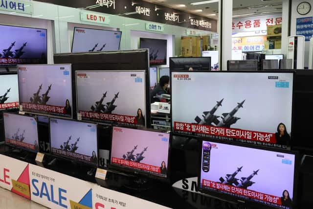 TV screens show a news program reporting about North Korea's ballistic missiles. The missiles fell into the Sea of Japan on Thursday, March 25.