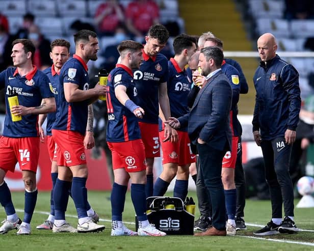 Lee Johnson talks with his Sunderland squad during a break in play in the first leg of their League One play-off semi-final against Lincoln City, which Lincoln won 2-0.