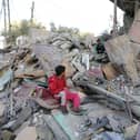 Boys sit amongst the rubble of a house in Rafah, Gaza, following Israeli air strikes this week.