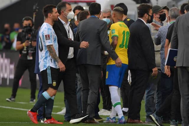 Argentina's Lionel Messi (L) and Brazil's Neymar are seen after employees of the National Health Surveillance Agency (Anvisa) entered to the field as controversy over Covid-19 protocols erupted. (Photo by NELSON ALMEIDA / AFP) (Photo by NELSON ALMEIDA/AFP via Getty Images)
