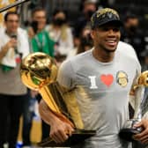 Giannis Antetokounmpo holds the Bill Russell NBA Finals MVP Award and the Larry O'Brien Championship Trophy after defeating the Phoenix Suns in Game Six to win the 2021 NBA Finals (Picture: Getty Images)