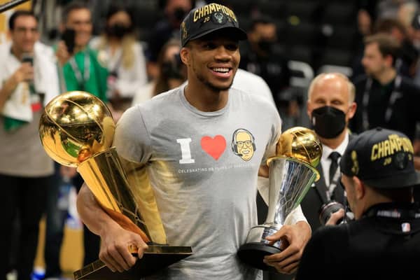Giannis Antetokounmpo holds the Bill Russell NBA Finals MVP Award and the Larry O'Brien Championship Trophy after defeating the Phoenix Suns in Game Six to win the 2021 NBA Finals (Picture: Getty Images)