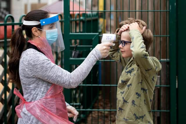 A member of staff takes a child's temperature at a school in June 2020 (Photo: Dan Kitwood/Getty Images)