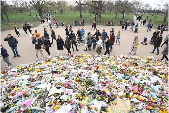 People viewing floral tributes left at the bandstand in Clapham Common, London, for Sarah Everard (PA)