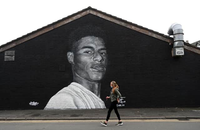 A pedestrian walks past a mural by graffiti artist Akse P19 of Manchester United football player Marcus Rashford -  MPs are set to debate Marcus Rashford child food poverty petition in parliament (Photo by PAUL ELLIS/AFP via Getty Images)
