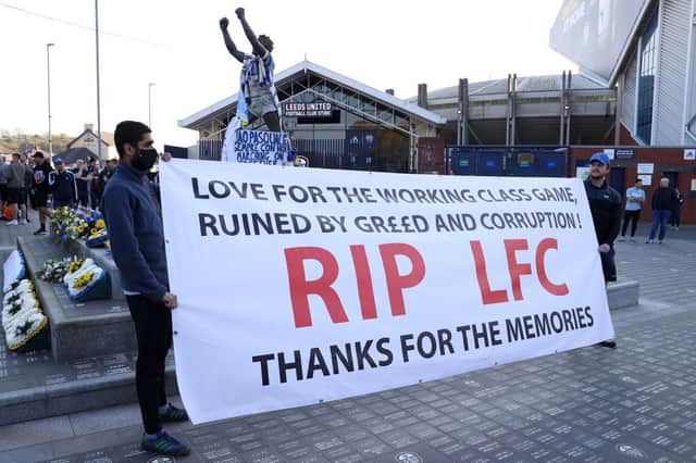 Fans hold up a banner in protest against the European Super League outside the stadium prior to the Premier League match between Leeds United and Liverpool at Elland Road.