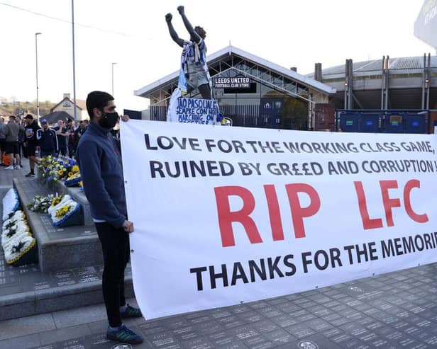 Fans hold up a banner in protest against the European Super League outside the stadium prior to the Premier League match between Leeds United and Liverpool at Elland Road.