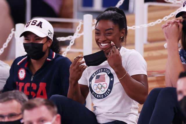 Simone Biles of Team United States smiles during the Women's Uneven Bars Final.
