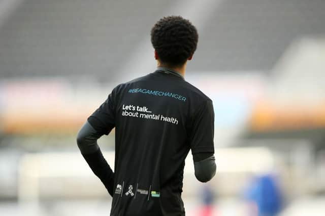 Jamal Lewis, of Newcastle United, is seen wearing a Be a Game Changer t-shirt. Football can play a key role in helping young men with mental health concerns.