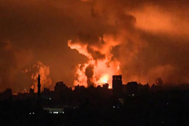 Balls of fire and smoke rising above Gaza City during an Israeli strike. (Picture: Yousef Hassouna / AFP via Getty Images)