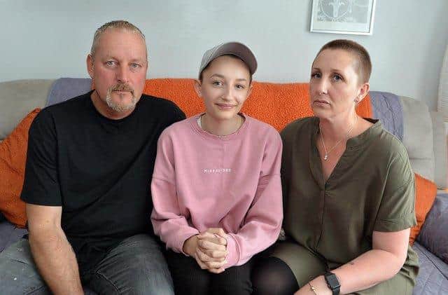 Ella Goodwin, 13, seen with parents Shaun and Joanne has lost her hair due to illness. She doesn't want to wear a wig but is being told she cannot wear a cap to school