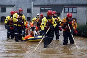 Members of the coastguard rescue team wade through the flood waters to evacuate a man and a dog in Brechin. The Met Office have issued three days of weather warnings. Picture: Jeff J Mitchell/Getty Images