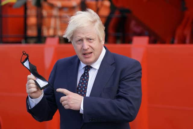 Boris Johnson holds a face mask before boarding the vessel Alba at Fraserburgh Harbour, Aberdeenshire on his way to the Moray Offshore Windfarm East on the second day of his two-day visit to Scotland (Photo: JANE BARLOW/POOL/AFP via Getty Images)