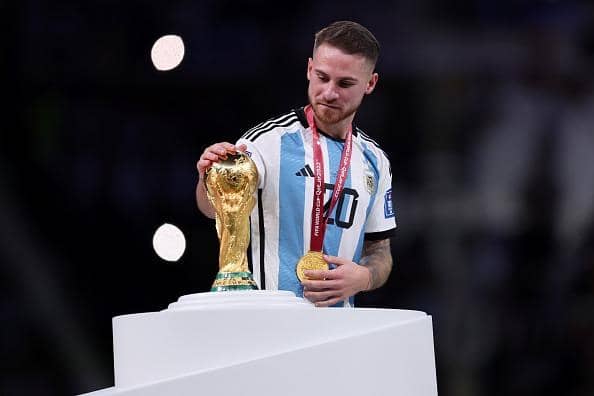 Brighton and Hove Albion midfielder Alexis Mac Allister of Argentina touches the World Cup trophy during the award ceremony